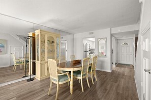Un coin repas avec une table et des chaises en bois, un meuble encastré et un lampadaire.