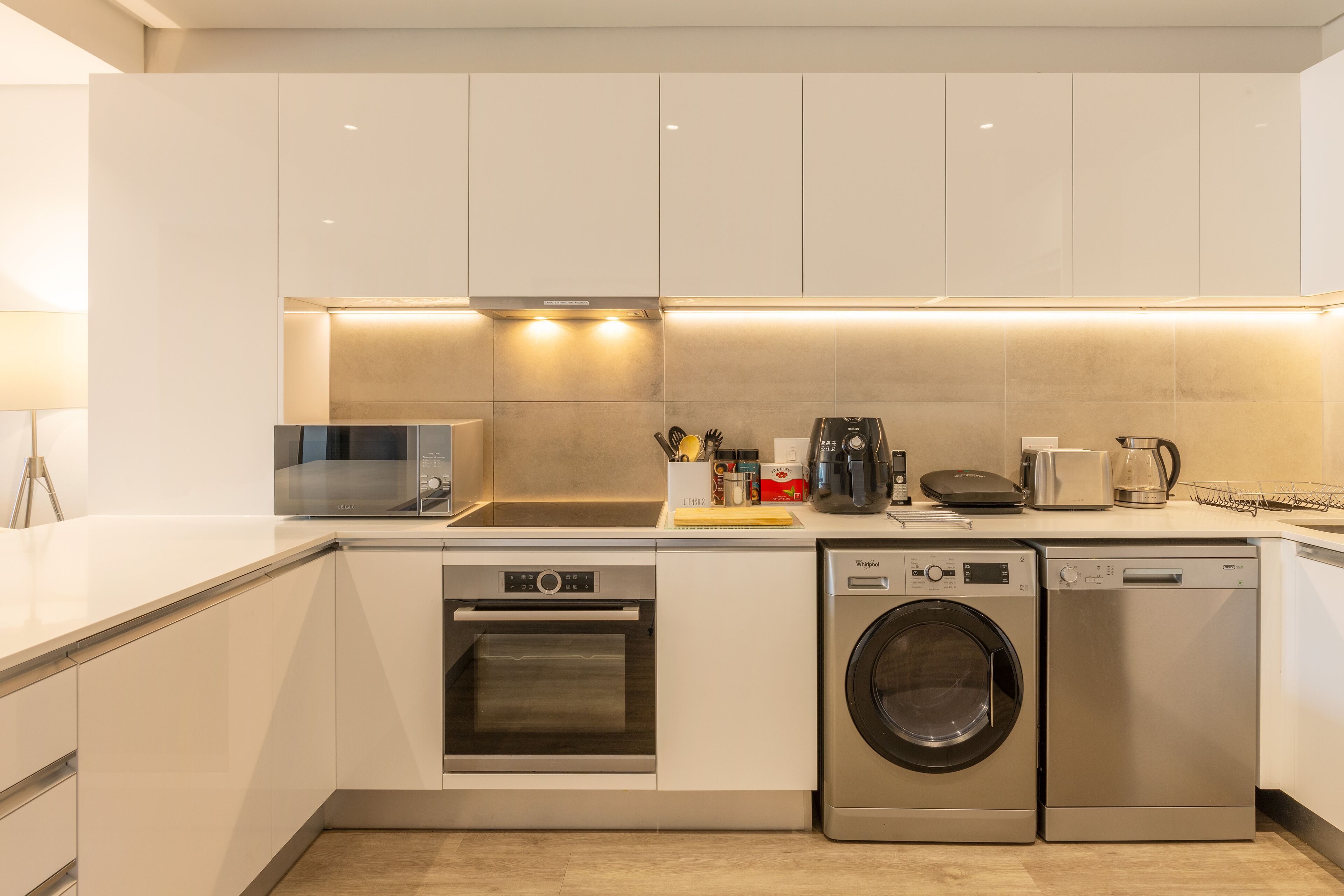 A modern kitchen with stainless steel appliances, including a microwave, oven, and dishwasher, and a countertop with various kitchen items.