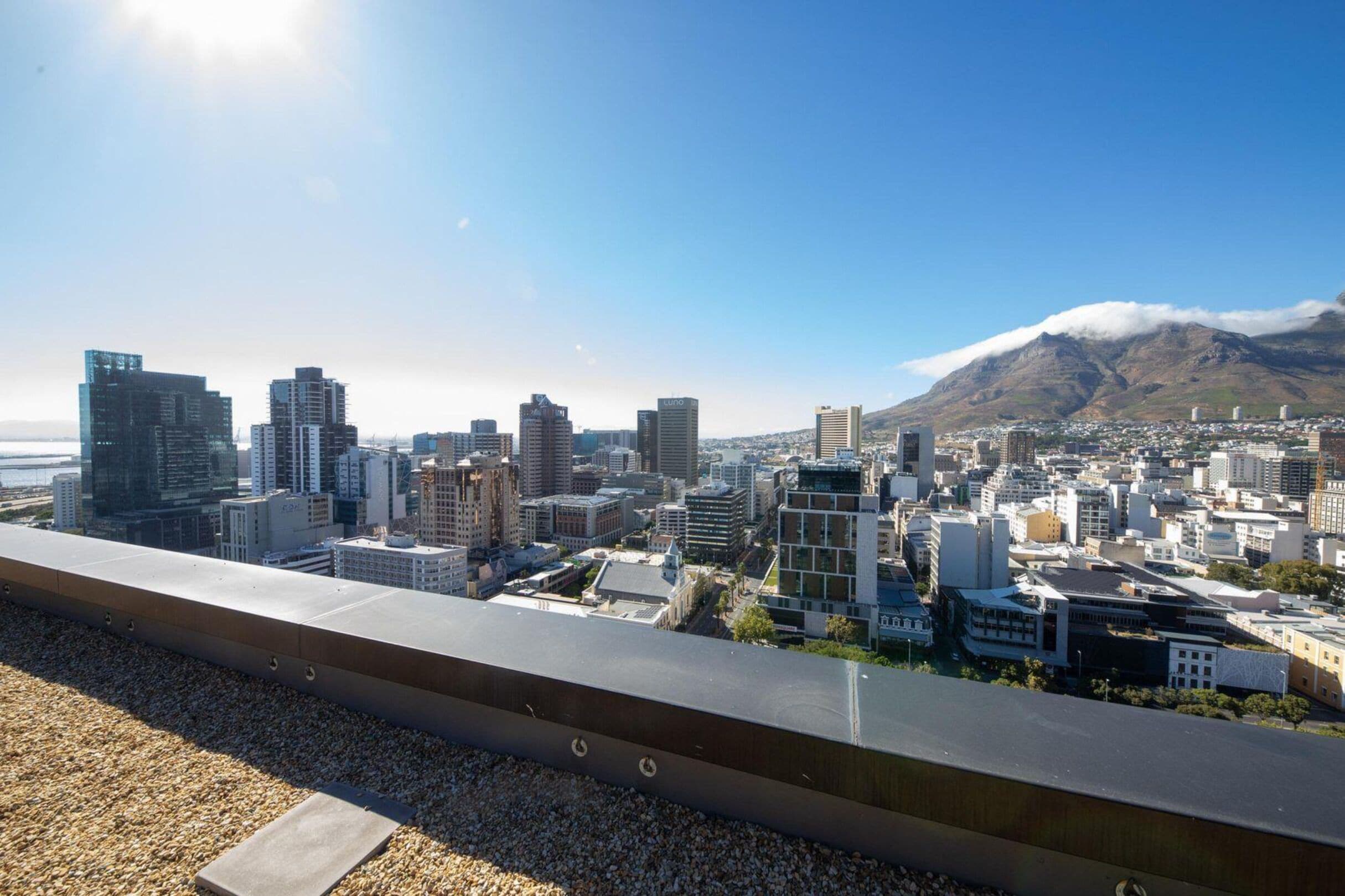 A cityscape with modern buildings and a mountain in the background.