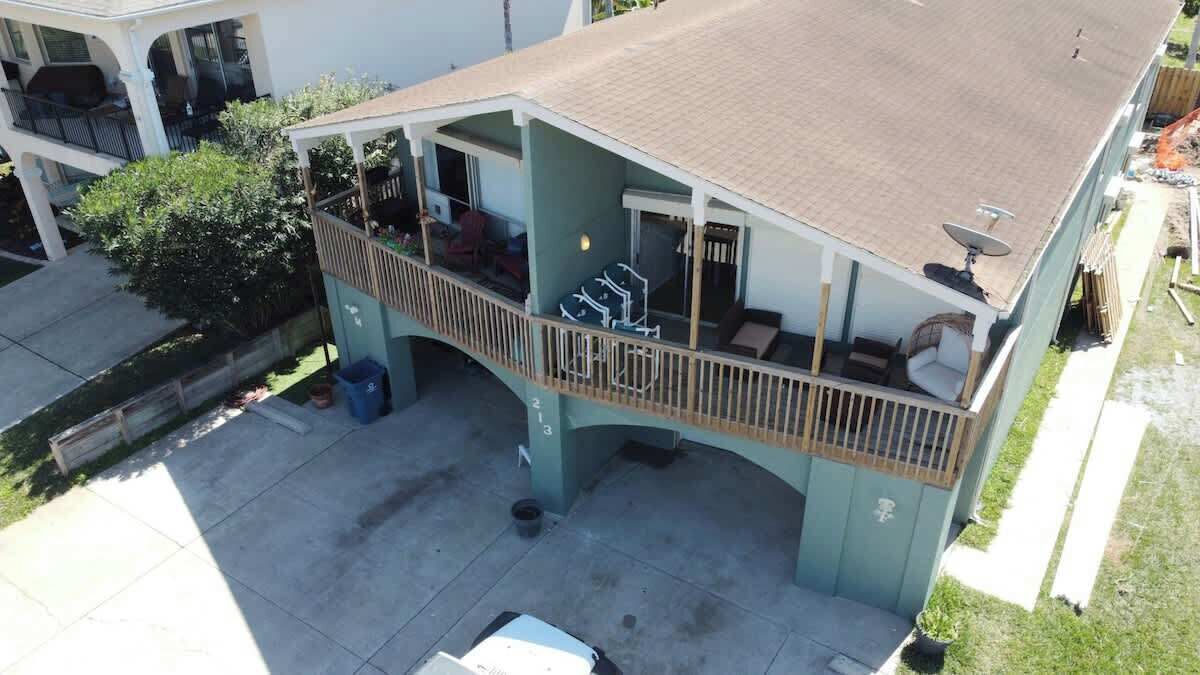 A two-story building with a covered patio area, a balcony, and a satellite dish.