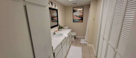 A bathroom with a sink, toilet, and shower.
