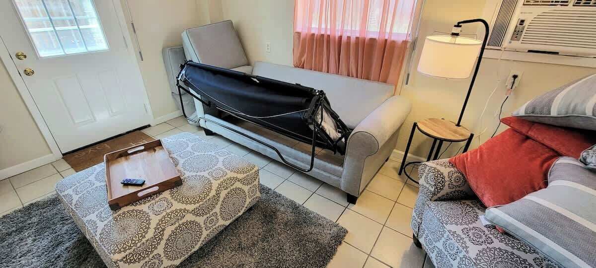 A compact living space with a sofa, a small table, and a patterned rug.