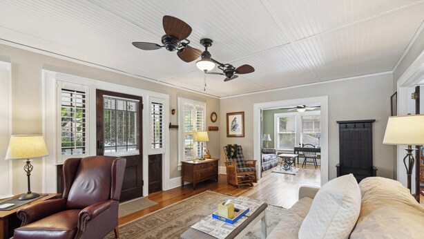 A living room with a leather armchair, a sofa, a coffee table, a fireplace, and a ceiling fan. - Historic House in Downtown Waynesville! With a firepit!  And Hot Tub 😄 (Waynesville)