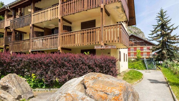 A multi-story building with balconies, a sign reading 'Residence Cretes,' and a mountain backdrop. - Studio cabin 4 ppl, parking, wifi (Valloire)