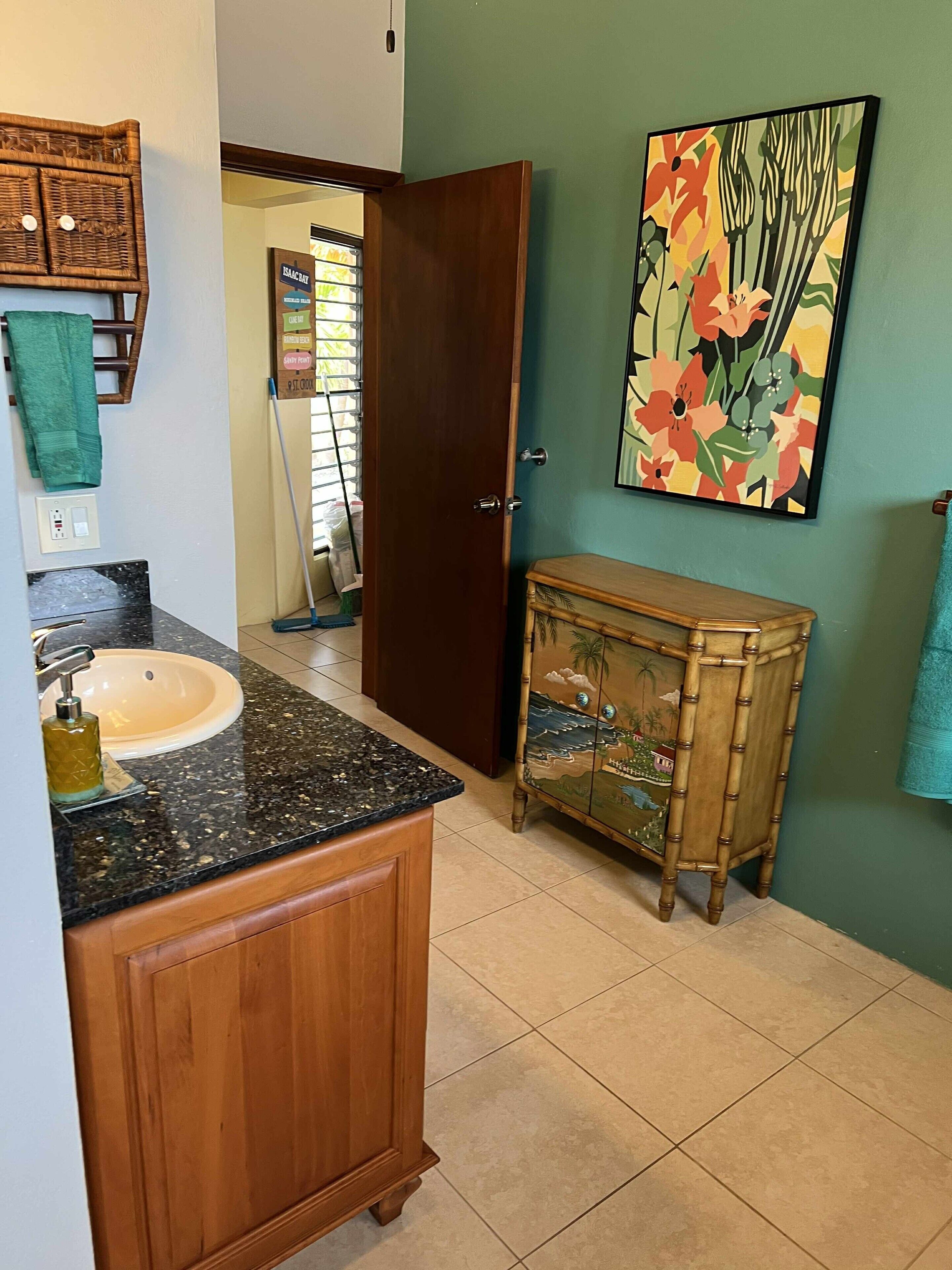 Un bagno con un mobile vanitario in legno, un lavandino e un armadietto decorativo.