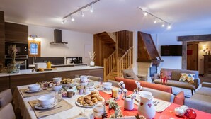 A modern kitchen with a dining area set for a meal. - Chalet 5 rooms, 12 guests, pets allowed, parking (Valloire)