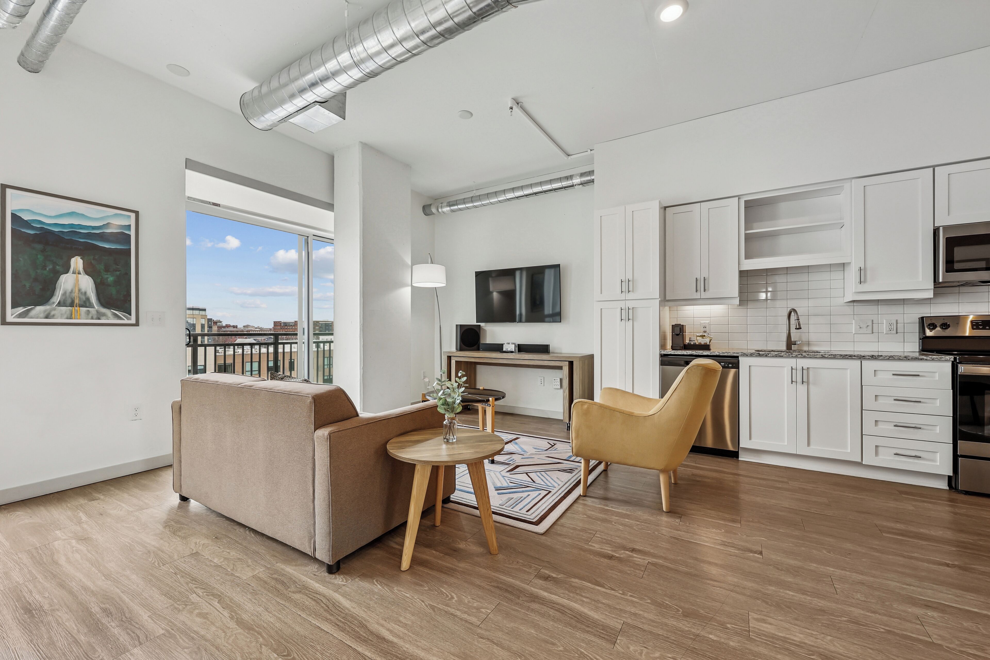 A modern apartment with a living room, kitchen, and dining area.