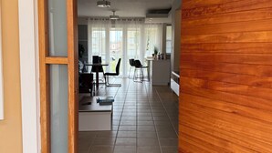 An open doorway leading into a living room with a dining area, a kitchen, and a view of the outside. - Palmas del Mar Family Vacation Resort Spot!   (Palmas del Mar)
