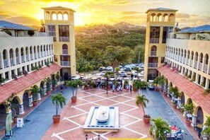A courtyard with a central fountain, surrounded by buildings with arched balconies and a tiled floor. - Palmas del Mar Family Vacation Resort Spot!   (Palmas del Mar)