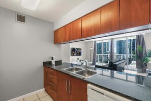 Eine moderne Küche mit Holzausstattung, einem doppelten Becken und Blick auf die Stadt durch große Fenster.