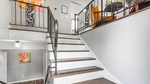A staircase with wooden steps and metal railings, leading to a second floor.
