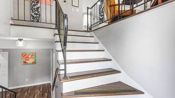 A staircase with wooden steps and metal railings, leading to a second floor.