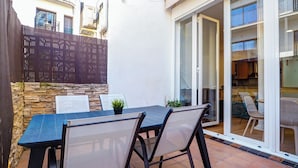 Eine Terrasse mit Tisch und Stühlen, einer Steinmauer und einem Holzzaun.
