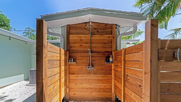 A wooden sauna with a tiled floor and a showerhead. - The Ivanhoe Getaway (Sarasota)