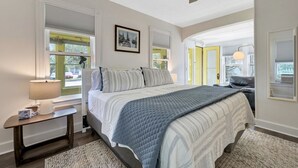 Un dormitorio con cama, mesita de noche, lámpara y ventilador de techo.