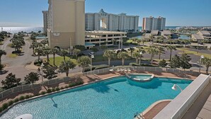A hotel with a large pool, palm trees, and a view of the ocean. -  Ariel Dunes l - Its Tannin' Time! - Fantastic Gulf Views! (Miramar Beach)