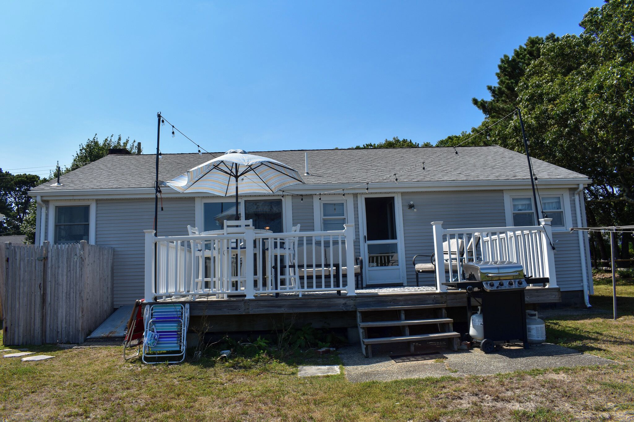 A single-story house with a front porch, a covered patio area, and a small deck.