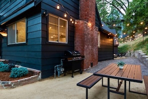 A house with a barbecue, outdoor seating, and string lights. - Black Pine - 4BR Lake Arrowhead Cabin | Family & Pet-Friendly (Lake Arrowhead)