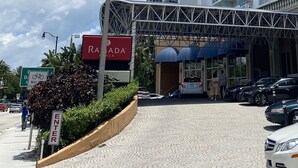 A hotel entrance with a sign for 'Ramada' and a pedestrian walkway. - Beachfront condo in Miami! (Sunny Isles Beach)