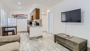 Un salon moderne avec un canapé, une table basse et un téléviseur fixé au mur.