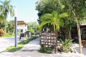 Ein Wegweiser mit Angaben zu verschiedenen Einrichtungen, darunter ein Restaurant, ein Park und eine Bildungseinrichtung.