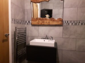 A bathroom with a white sink, a mirror with a wooden frame, and a towel rack. - Ever Wanted to go off Grid,then This is for you (Sutton Coldfield)