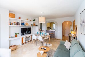 A modern living room with a TV, dining table, and sofa. - Cubo's Apartment Las Acacias Beach / air conditioning / free wifi / pool (La Cala de Mijas)