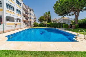 A swimming pool surrounded by a fence, with a building in the background. - Cubo's Apartment Las Acacias Beach / air conditioning / free wifi / pool (La Cala de Mijas)
