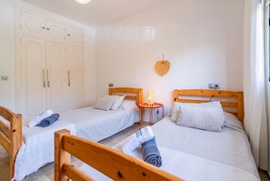 A hotel room with two single beds, a wooden headboard, a bedside table with a lamp, and a wall-mounted heart decoration. - Cubo's Apartment Las Acacias Beach / air conditioning / free wifi / pool (La Cala de Mijas)