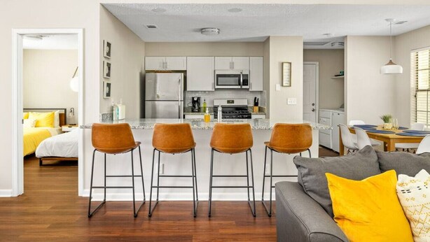 Eine moderne Wohnung mit Küche, Essbereich und Wohnzimmer.