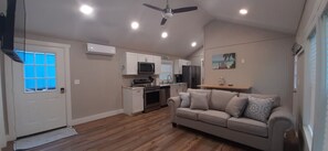 A compact living space with a kitchenette, a sofa, and a ceiling fan.