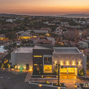 A modern hotel with a pool, a rooftop terrace, and a view of the surrounding neighborhood.