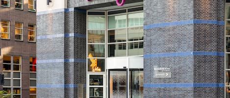 Entrada de un hotel con un letrero que dice 'mozy', un letrero de 'Residence Inn by Marriott' y un letrero de 'Bienvenido'.