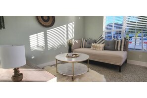 Relax in this inviting living space with a comfortable sofa, coffee table, and potted plant.