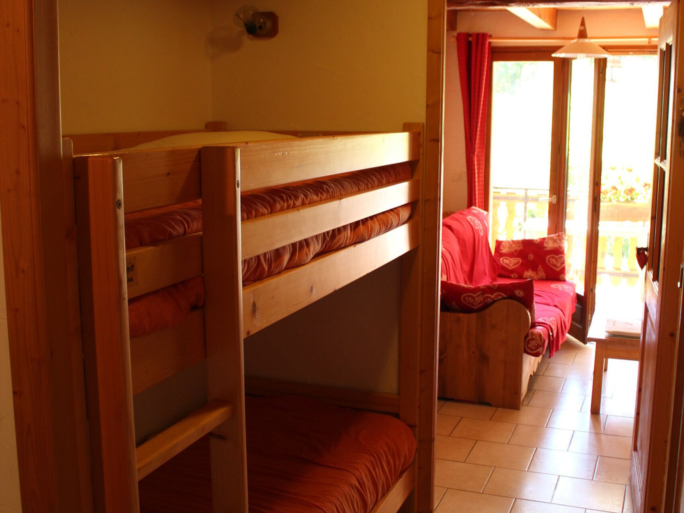 A bunk bed room with a view of a balcony.