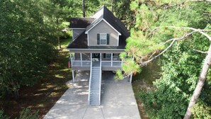A two-story house with a front porch and a small staircase leading to the entrance.