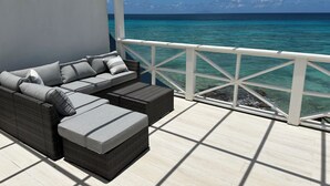 A covered outdoor seating area with a view of the ocean. - Stunning Beach Front Villa With Infinity Pool  (Pelican Key, Simpson Bay)