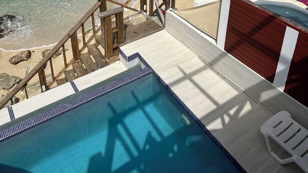 A pool area with a view of the beach and ocean. - Stunning Beach Front Villa With Infinity Pool  (Pelican Key, Simpson Bay)