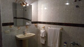 A bathroom with a sink, mirror, towel rack, and shower. - Pensión Mari Loli (Guardamar del Segura)