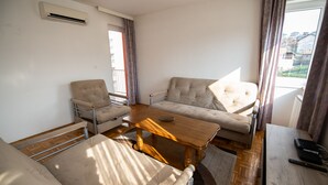 Ein Wohnzimmer mit einer Couch, einem Sessel und einem Couchtisch aus Holz.