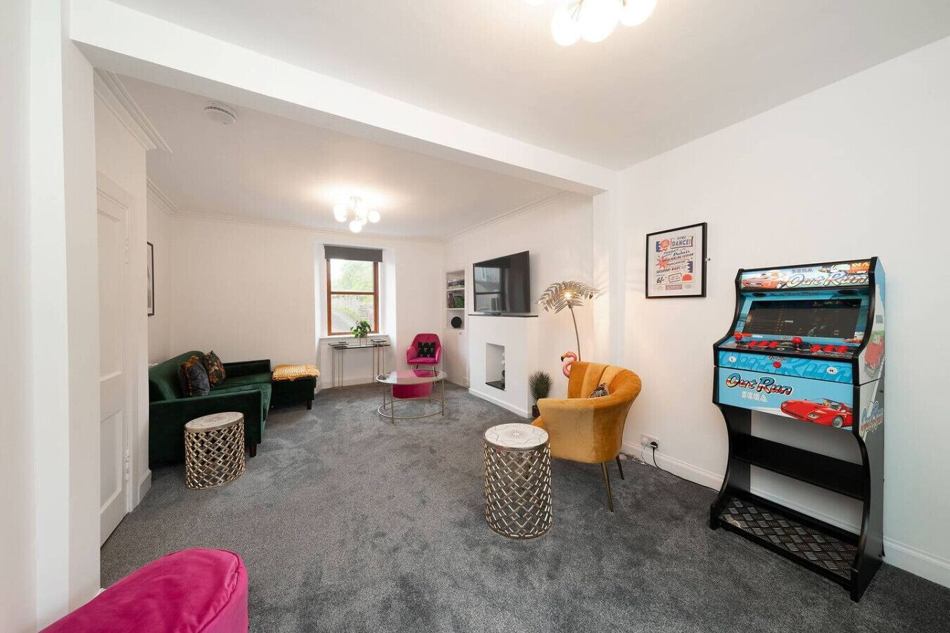 Ein kompakter Wohnbereich mit Sofa, Sesseln, einem kleinen Tisch, einer Spielkonsole und einem Fernseher.