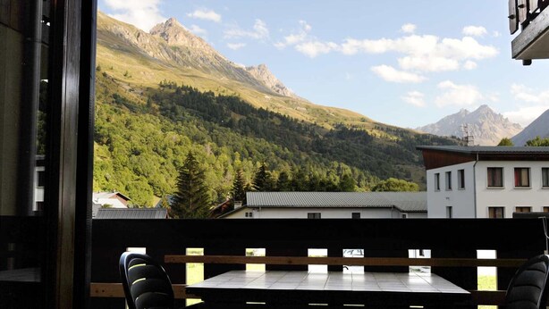 A balcony with a table and chairs overlooking a mountainous landscape. - 2-room apt, 4 pers, south-facing with balcony in Valloire (Valloire)