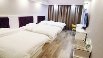 A hotel room with two beds, a desk, a chair, and a TV.