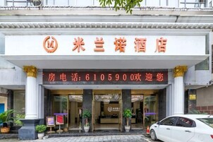 Entrada de hotel com um letreiro em caracteres chineses e um número de telefone.