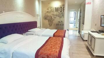 Habitación de hotel con dos camas, cabecero, escritorio con silla y pared con palabras motivacionales.