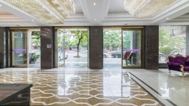A spacious lobby with a patterned floor, large glass doors, and a purple sofa. - Milannuo Business Hotel (Xing'an County)