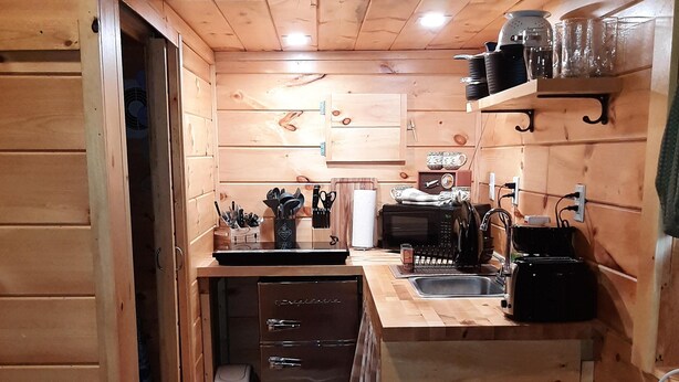 A compact kitchen with wooden cabinets, a refrigerator, a sink, and a toaster. - Unique, Cozy Stay near Red River Gorge (Slade)