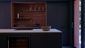 Eine moderne Küche mit einem Holzboden, einer Spüle und einer großen Schüssel auf der Arbeitsplatte.