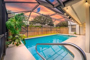 A swimming pool with a glass ceiling, surrounded by a wooden fence and potted plants. - Poolside Golf Paradise: 2 King Bdrms: Beaches 15 Min: Game room: Tee, Sun & Fun (Fort Pierce)