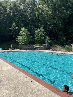 Relax by the Riverside Pool, surrounded by a deck and lush trees.
